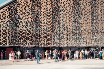 Le Bâtiment de la Grande Halle vue de face avec une foule de personnes devant l'entrée